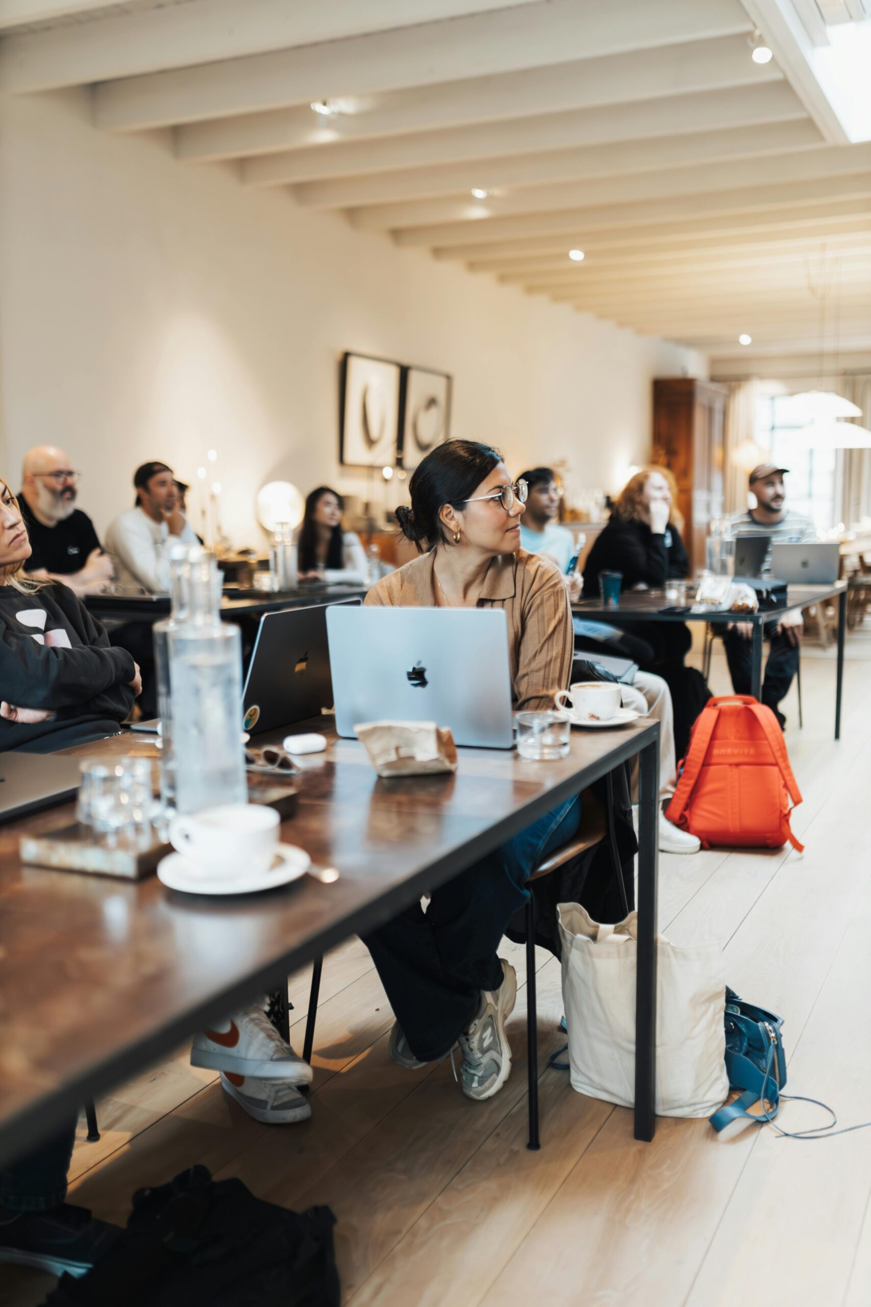 Diverse team engaged in a business conference using laptops and technology.